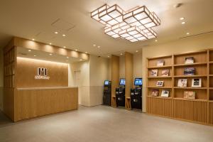 een lobby met twee pinautomaten in een gebouw bij hotel MONday Tokyo Nishikasai in Tokyo