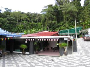 a building with a patio with plants in it at Darulmakmur Chalet in Cameron Highlands