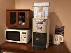 una macchinetta del caffè e un forno a microonde su un bancone di Restay Mito (Adult Only) a Mito
