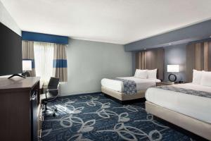 a hotel room with two beds and a television at Baymont Inn & Suites Shawnee in Shawnee +24 photos