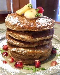 a stack of pancakes with fruit on a plate at Harlem Stonegate B&B in Portland