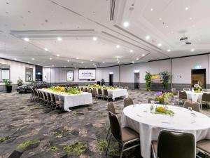 a banquet hall with white tables and chairs at Novotel Sydney International Airport in Sydney +126 photos
