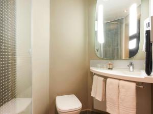 a bathroom with a toilet and a sink and a mirror at ibis Jerusalem city Center - An AccorHotels Brand in Jerusalem