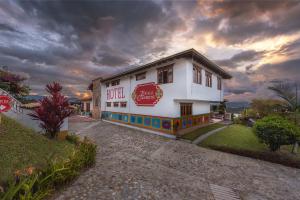 a white building with a sign on the side of it at Hotel Zocalo Campestre in Guatapé