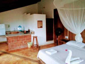 a bedroom with a bed and a kitchen with a sink at Villa Luna de Miel in Mazunte