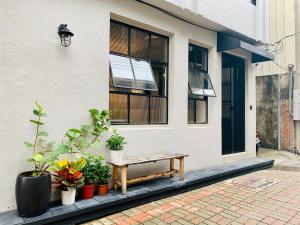 a wooden bench sitting outside of a building with plants at Ho.Me-Easyhouse -II in Tainan