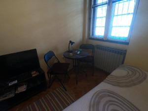 Pokój ze stołem, 2 krzesłami i łóżkiem w obiekcie Aprtman Sonja 2 w Belgradzie