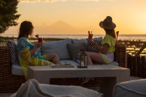 two women sitting on a couch watching the sunset at Gili Eco Villas in Gili Trawangan