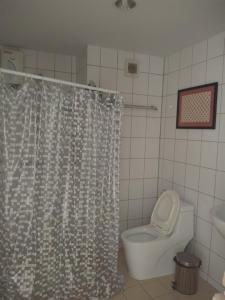 a bathroom with a toilet and a shower curtain at GrandBeach Condo by malai in Rayong