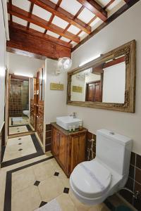 La salle de bains est pourvue de toilettes, d'un lavabo et d'un miroir. dans l'établissement Dodhia Haveli, à Ahmedabad