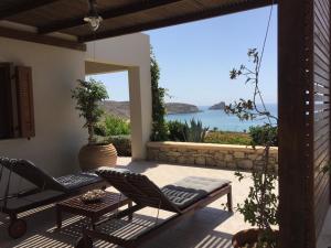 a patio with chairs and a view of the water at Natica Mare Villas in Xerokampos