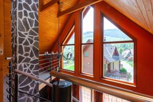 a room with a window with a view of a house at Winter & Summer - Chalets in Ždiar