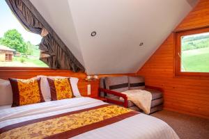 a bedroom with two beds and a chair and a window at Winter & Summer - Chalets in Ždiar