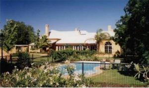 a large house with a swimming pool in front of it at Ranelagh House in Dubbo