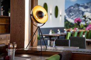 żółtą lampę siedzącą na stole w restauracji w obiekcie Boutique Hotel Olympia w mieście Seefeld in Tirol