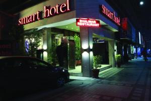 un coche aparcado fuera de un hotel inteligente por la noche en Smart Hotel en Lahore