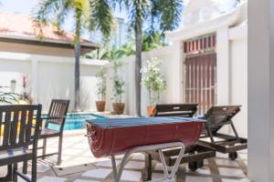 a table and chairs on a patio with a pool at AnB poolvilla 2BR with private beach in pratamnak in Pattaya South