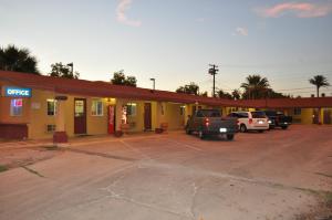 a gas station with cars parked in a parking lot at California Suites Motel in Calexico