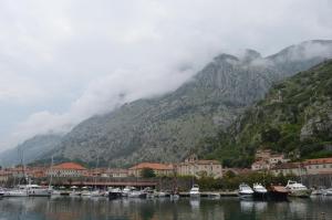 a bunch of boats in a harbor with a mountain at Apartments Qualitas in Kotor