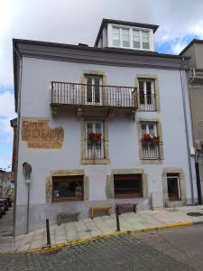 a white building with windows and balconies on a street at Apartamento Cine Colón in Ribadeo