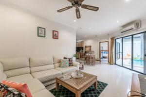 a living room with a couch and a table at AnB poolvilla 2BR with private beach in pratamnak in Pattaya South