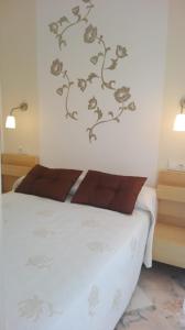 1 dormitorio con cama blanca y almohadas marrones en Romana Playa 7, Soleuropa en Marbella