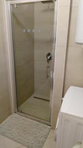W łazience znajduje się prysznic ze szklanymi drzwiami. w obiekcie Art Apartman w mieście Jeziora Plitwickie