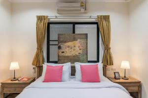 a bedroom with a bed with two pink pillows at AnB poolvilla 2BR with private beach in pratamnak in Pattaya South +32 photos