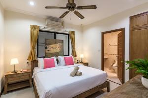a bedroom with a large white bed with pink pillows at AnB poolvilla 2BR with private beach in pratamnak in Pattaya South