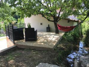 uma rede pendurada numa árvore ao lado de uma casa em Gîte dans le sud Aveyron em Saint-Affrique