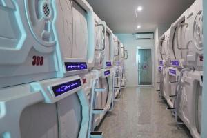 een kamer met een rij wasmachines en drogers bij Shakti Capsule Hotel Jakarta in Jakarta