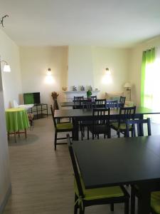 a dining room with tables and chairs and a television at Nature Guesthouse in Lagos