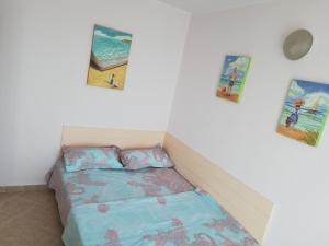 a bed in a room with three pictures on the wall at Cozy studio #1, with balcony in 2 Mai