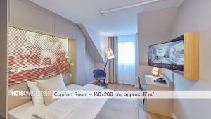 a hotel room with a bed and a flat screen tv at Hotel Wettstein in Basel