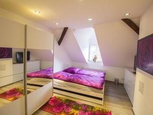 two beds in a room with purple sheets at Ferienwohnung Innenstadt in Oberkirch