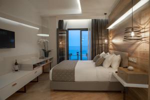 Seasabelle Hotel near Athens Airport في أرتيميدا: غرفة نوم مع سرير وإطلالة على المحيط