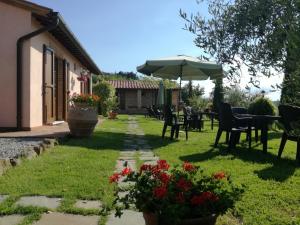 einen Garten mit einem Tisch, Stühlen und einem Sonnenschirm in der Unterkunft La Pievina in Montepulciano