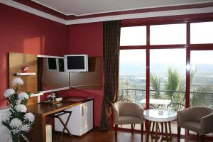 una sala de estar con paredes rojas y una gran ventana. en Nysa Hotel, en Sultanhisar