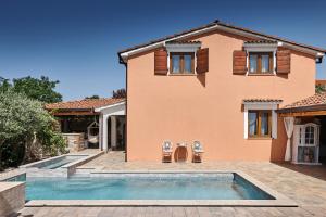 a house with a swimming pool in front of it at Villa Amelie in Kaštelir