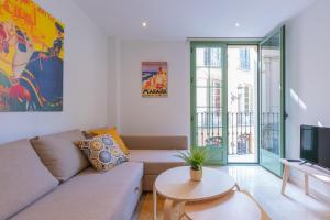 un soggiorno con divano e TV di Apartamentos Miraflores a Málaga