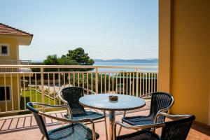 ラッシにあるLassi Hotelのテーブルと椅子4脚、海の景色を望むバルコニー