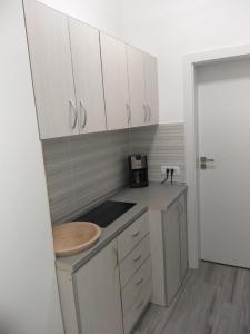 Una cocina con gabinetes blancos y encimera. en Frontal view by Twin Residence, en Mamaia 19 fotos más