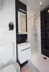 a bathroom with a toilet and a sink and a shower at Logis Les Voiliers in Peigney