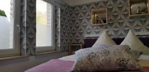 sypialnia z łóżkiem i ścianą z oknami w obiekcie Pension ILMHOF w mieście Bad Berka