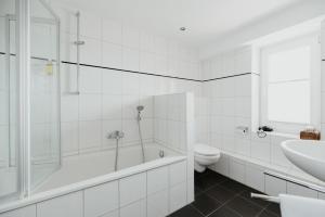 a bathroom with a tub and a toilet and a sink at Siel59 Hotel & Restaurant in Ockholm