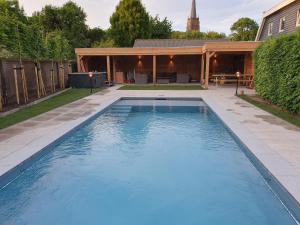 a swimming pool in the backyard of a house at B&B Resort Tremele in Dreumel