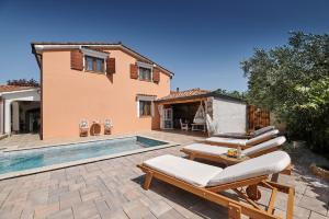 a villa with a swimming pool next to a house at Villa Amelie in Kaštelir