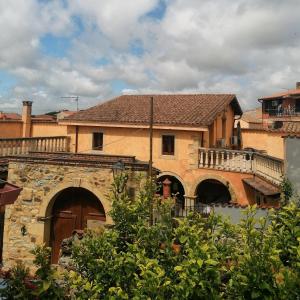 un grande edificio con balcone e un edificio alberato di Casa Susanna Rural Sardinia a Sini