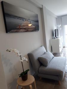 a living room with a couch and a tv on the wall at NEW Arenal Studio in Jávea