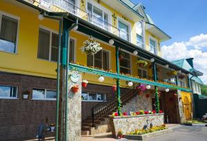 a yellow building with flowers in front of it at Hantri Hotel in Sergiyev Posad